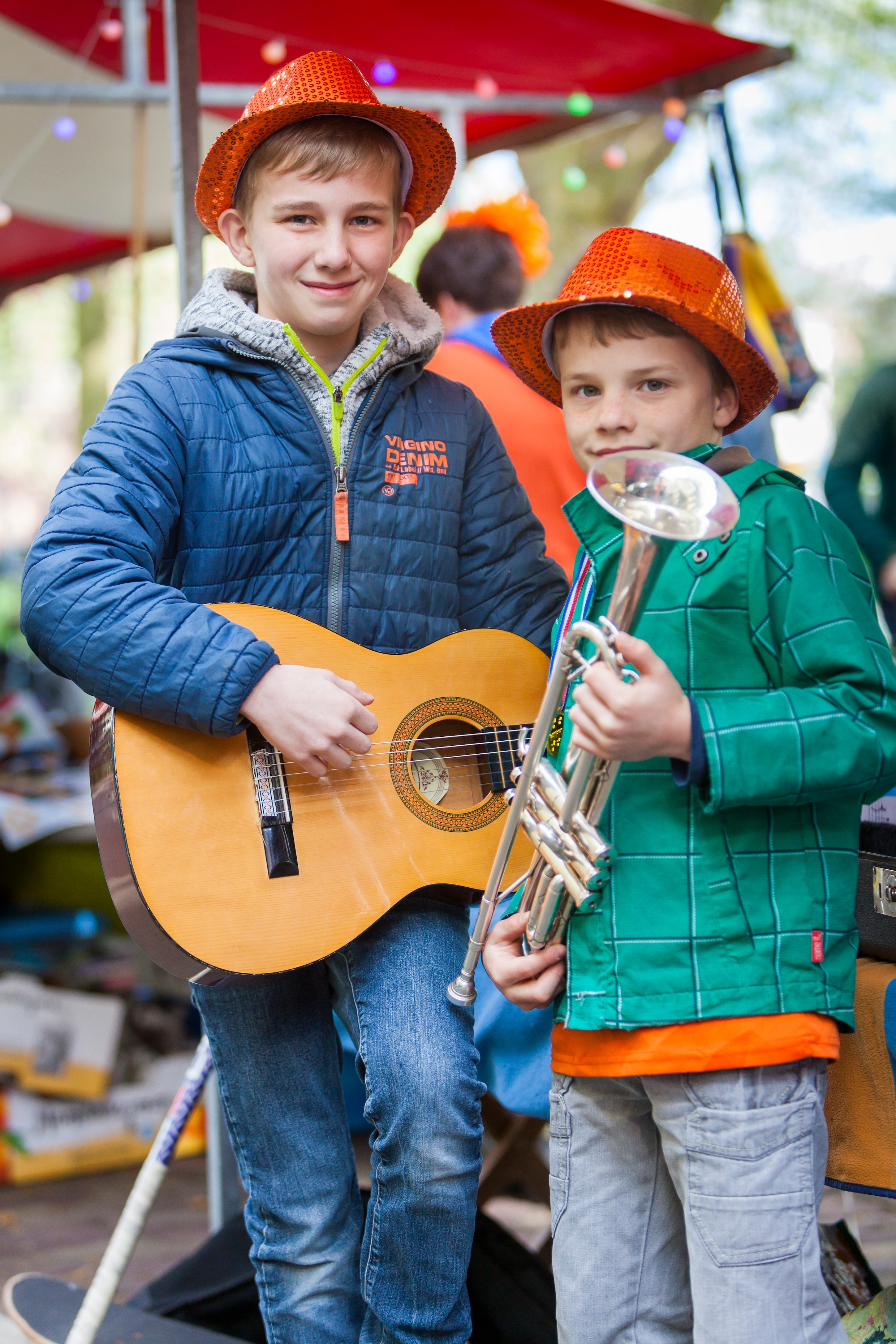 Noud Crijns (12) en zijn broer Krijn (9) spelen gitaar (Noud) en verkopen wafels (Krijn).