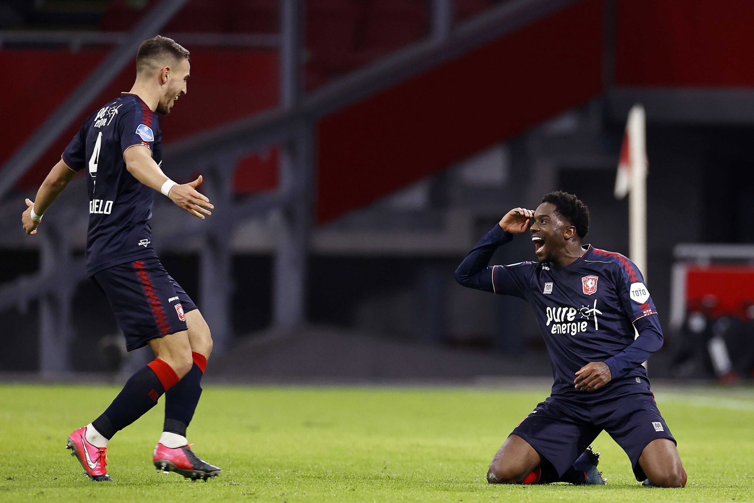 Twente-aanvaller Queensy Menig viert zijn tweede en beslissende treffer tegen Ajax met Julio Pleguezuelo (l).