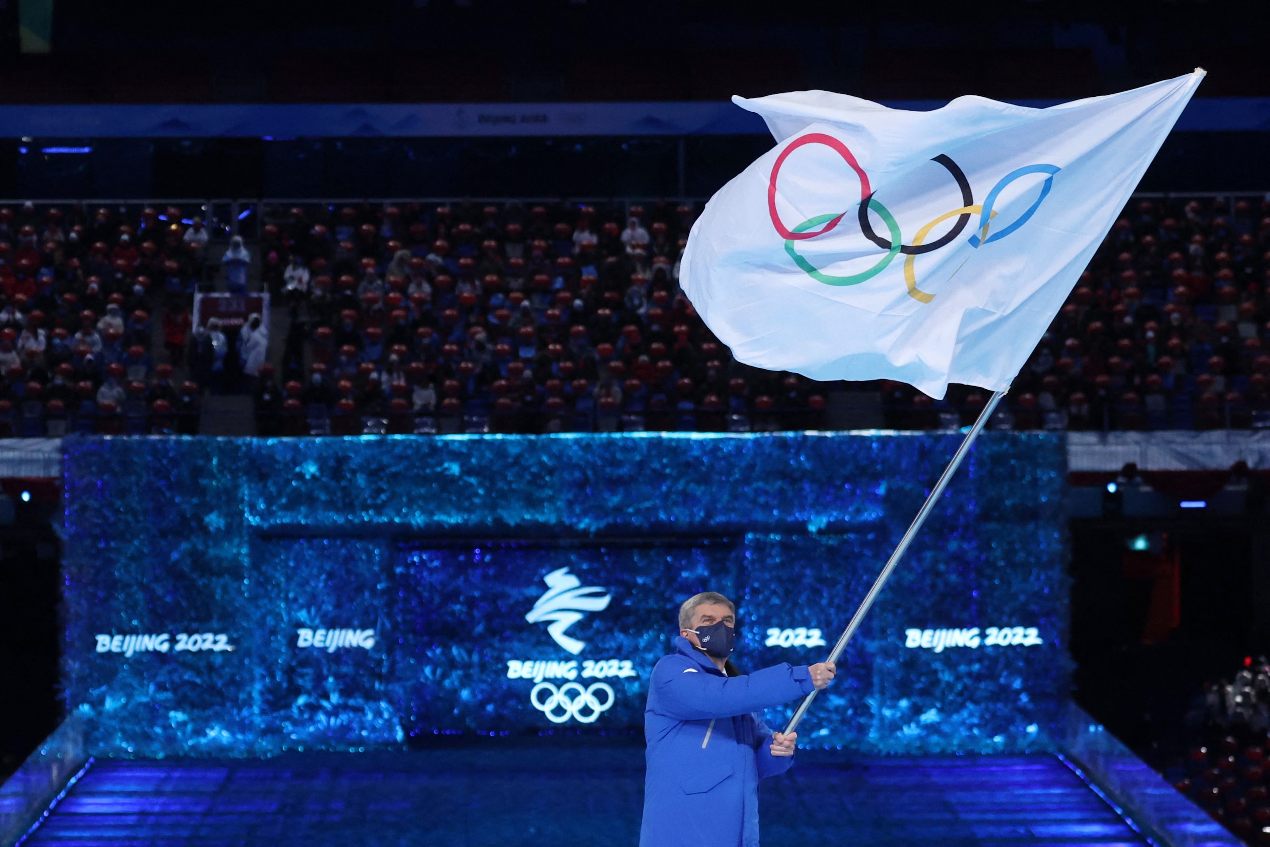 Internationaal Olympisch Comité (IOC) Voorzitter Thomas Bach zwaait met de Olympische vlag. 