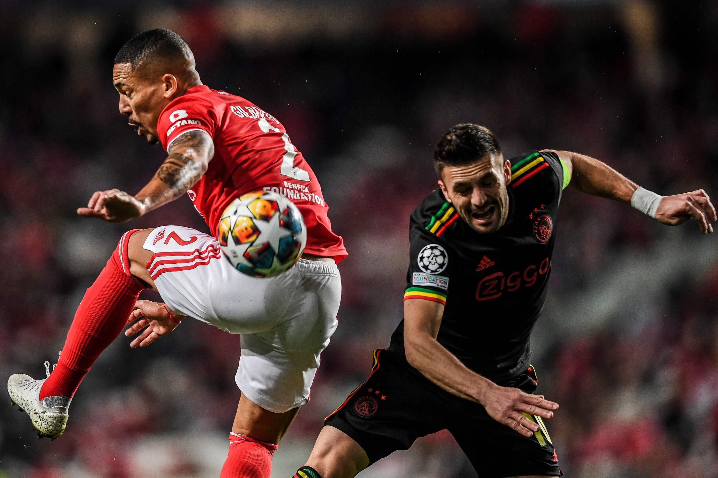 Een luchtduel tussen Benfica-verdediger Gilberto Junior (links) en Ajax-aanvoerder Dusan Tadic.