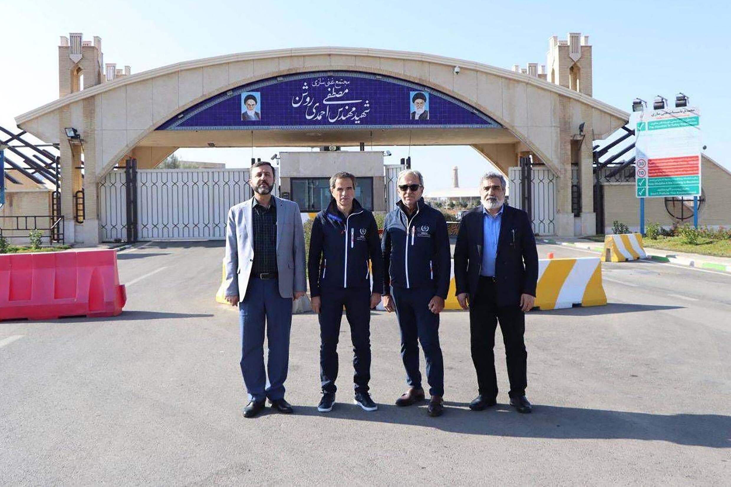 Een delegatie van het Internationaal Atoomenergieagentschap (IAEA) poseert samen met de Iraanse onderminister van Buitenlandse Zaken en een Iraanse woordvoerder voor de ingang van de Natanz complex, waar het land uranium verrijkt.