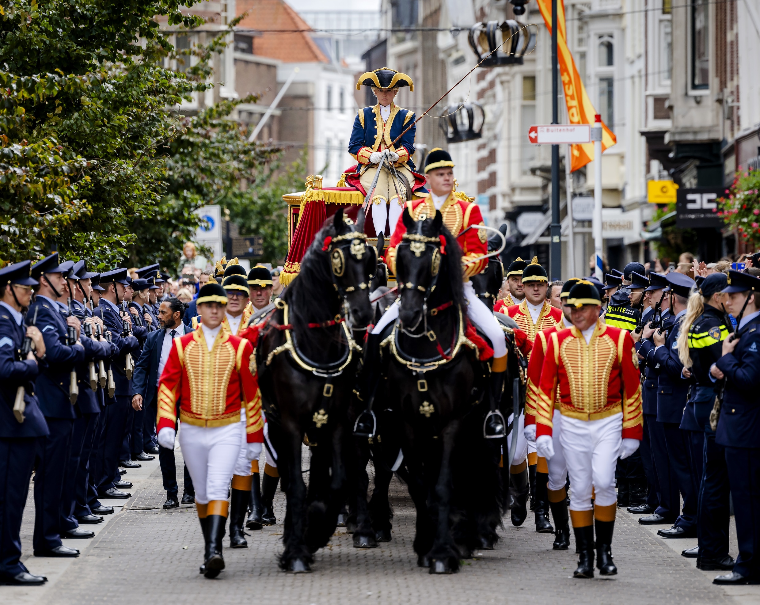 De glazen koets met daarin de koning en de koningin.