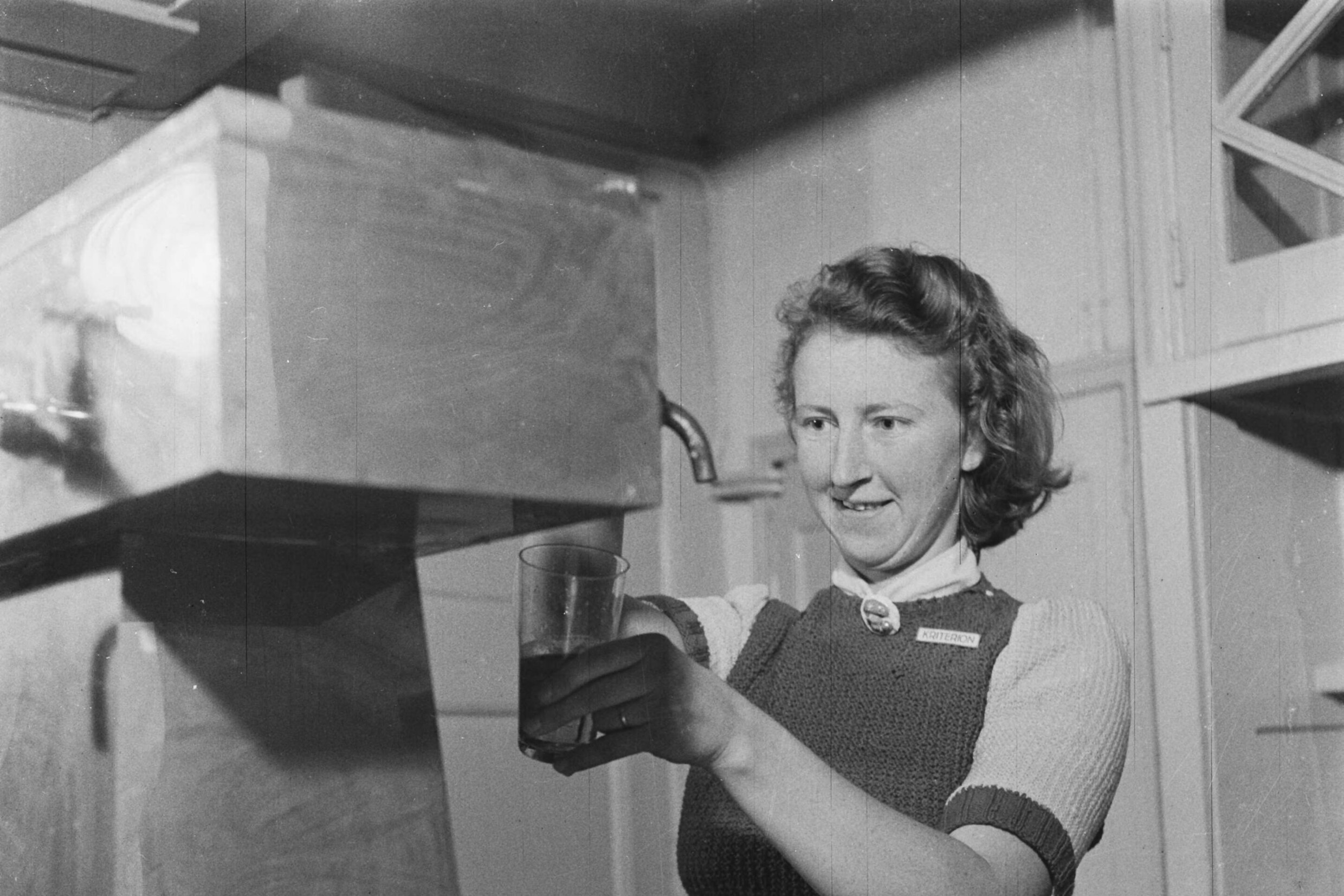 Een medewerkster van studentenbioscoop Kriterion tapt bier, 1945.