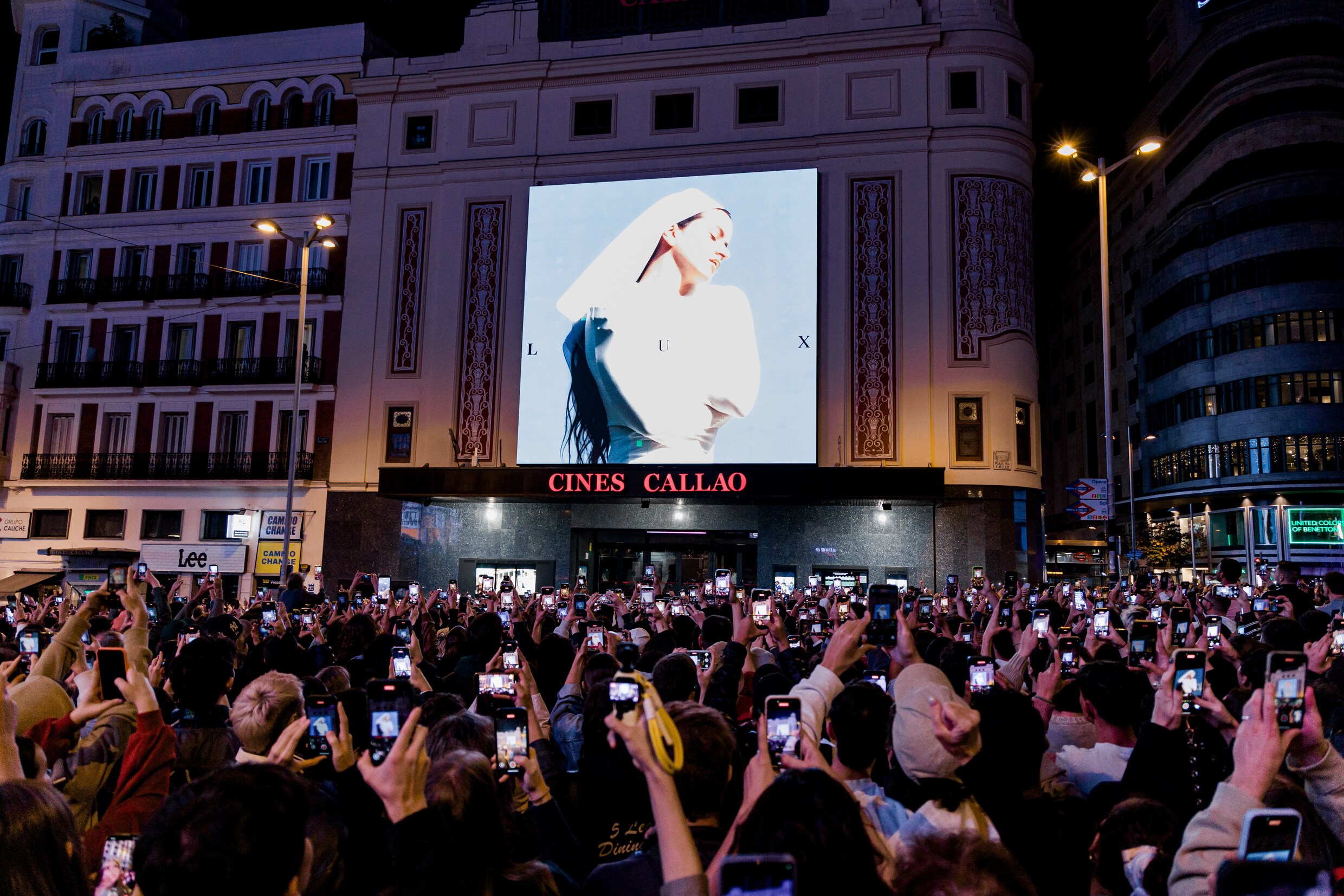 Fans van Rosalía bekijken de aankondiging van het nieuwe album van Rosalia op een plein in Madrid.