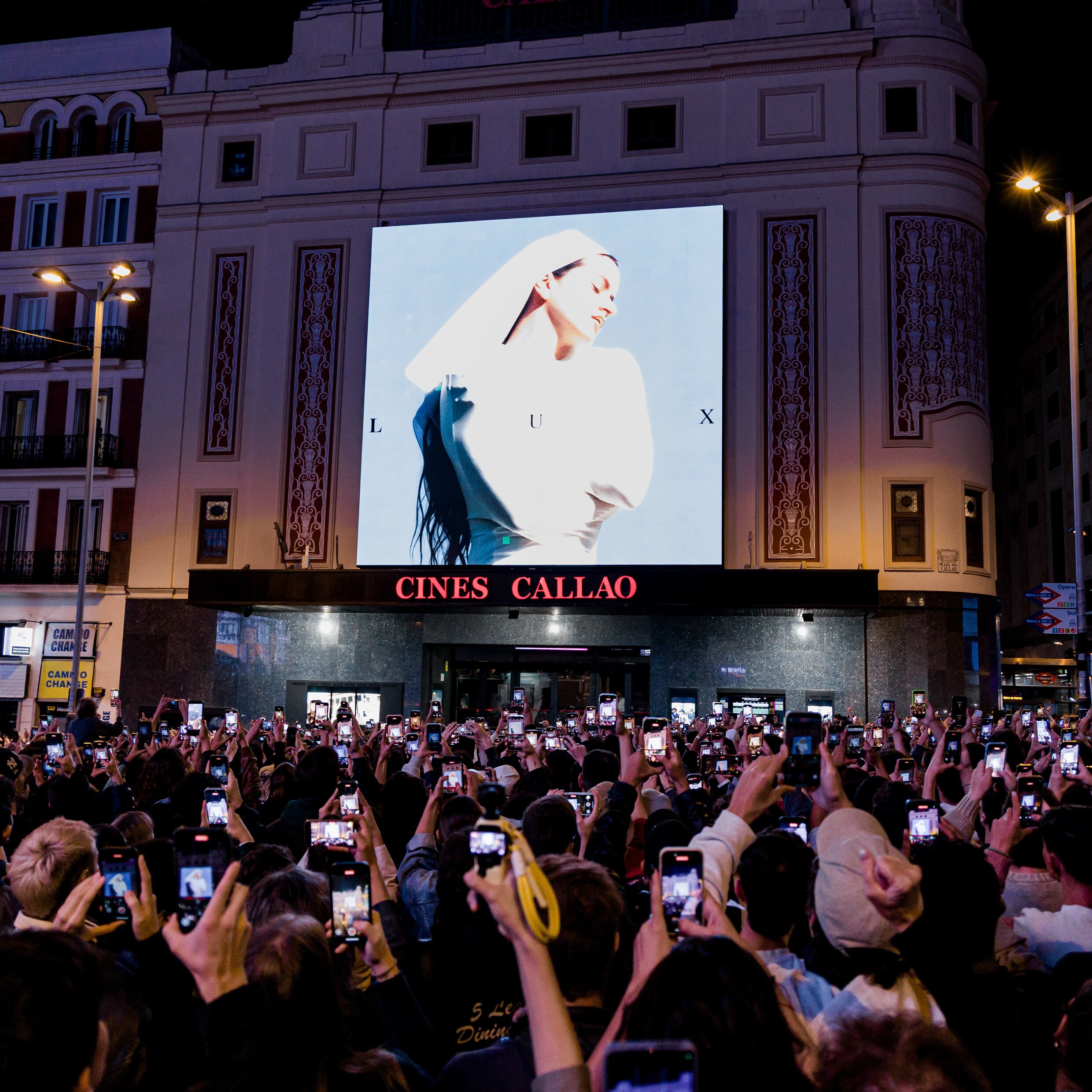 Fans van Rosalía bekijken de aankondiging van het nieuwe album van Rosalia op een plein in Madrid.