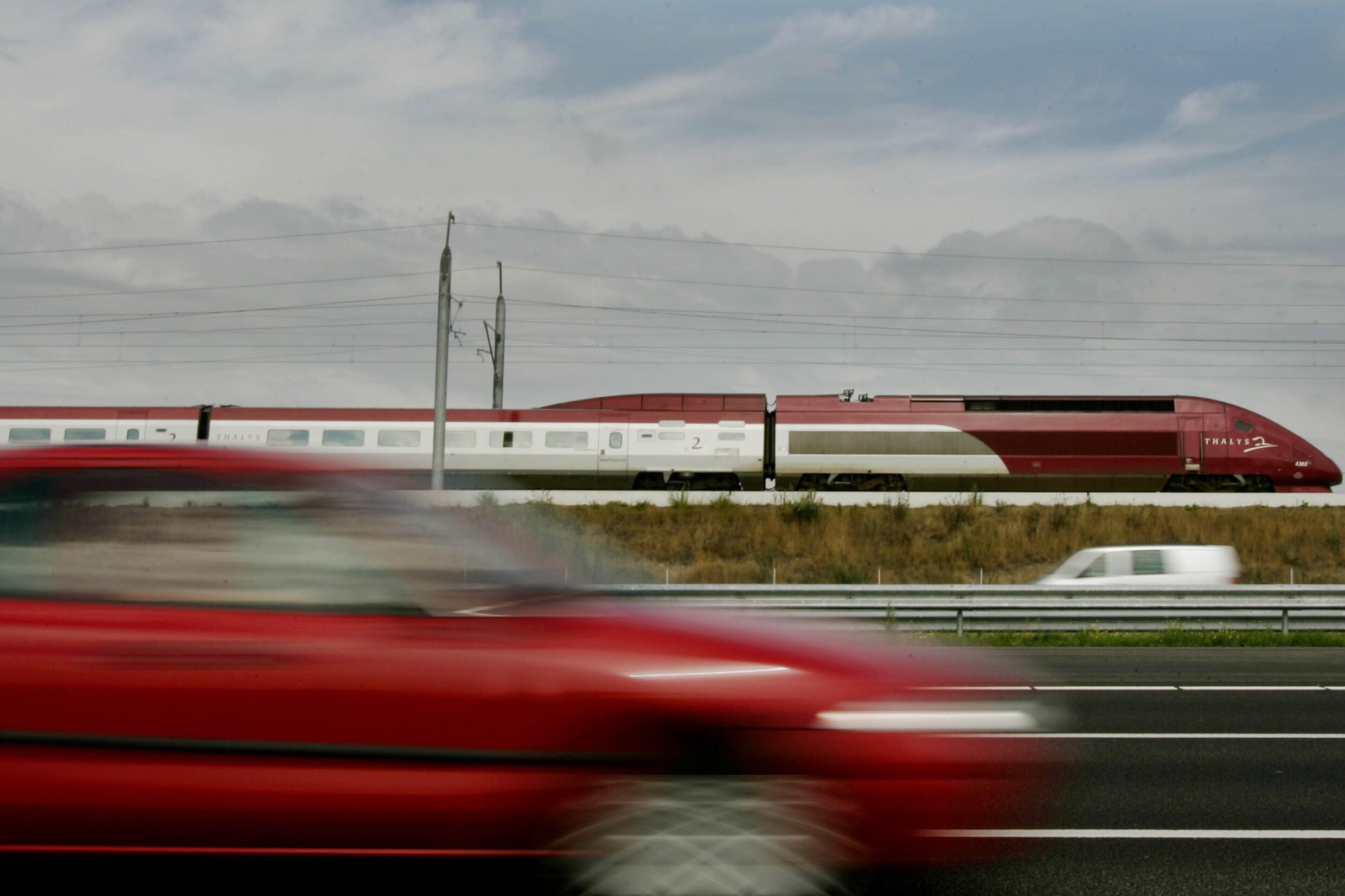 Een Thalys-trein passeert automobilisten die over de A4 vanaf Schiphol richting Den Haag rijden. Deze hsl-trein heet inmiddels Eurostar.