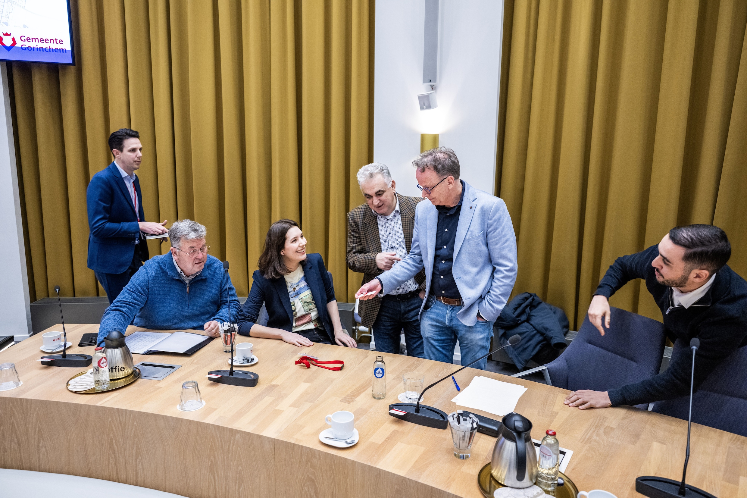 Raadsleden in overleg tijdens de schorsing van de raadsvergadering op het stadhuis.