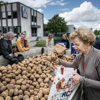 Actievoerders delen bio-aardappelen uit voor de deur van Ald