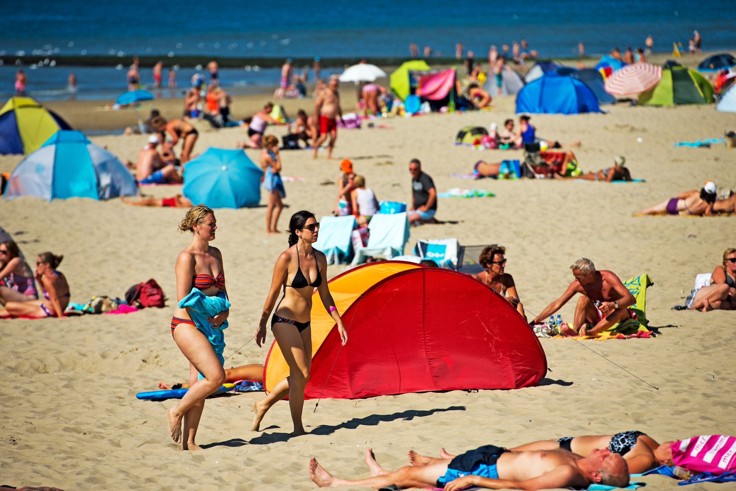 Op een het zomerdag zoeken badgasten op Texel verkoeling op het strand.